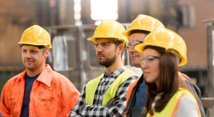 Steel,workers,listening,in,meeting,in,factory